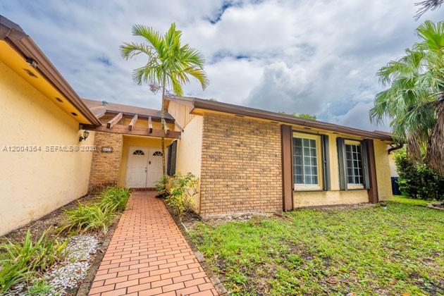 A brick and stucco house features a brick walkway leading to a double front door — 5501 SW 147th Pl, Miami FL 33185, MIAMI, FL