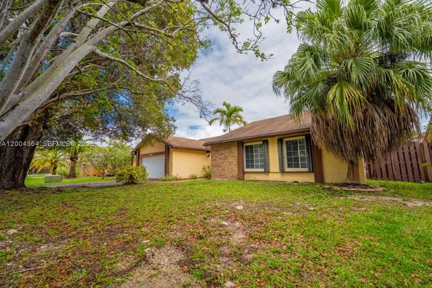 A single-story house with a yellow exterior, a garage, and a large palm tree — 5501 SW 147th Pl, Miami FL 33185, MIAMI, FL