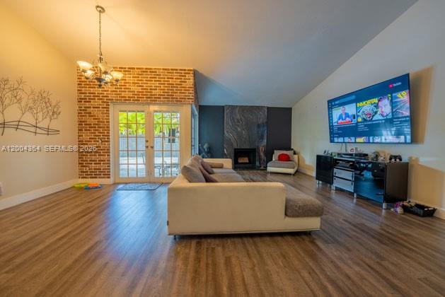A living room features a brick accent wall, a fireplace, a sectional sofa, and wood flooring — 5501 SW 147th Pl, Miami FL 33185, MIAMI, FL