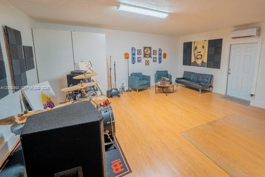 A spacious room with light wood flooring, a drum set, seating area, and wall art — 5501 SW 147th Pl, Miami FL 33185, MIAMI, FL