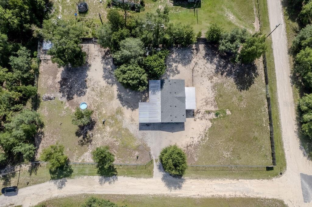 An aerial view shows a house with a metal roof on a large, sandy lot — 7491 NE 101ST COURT, BRONSON, FL