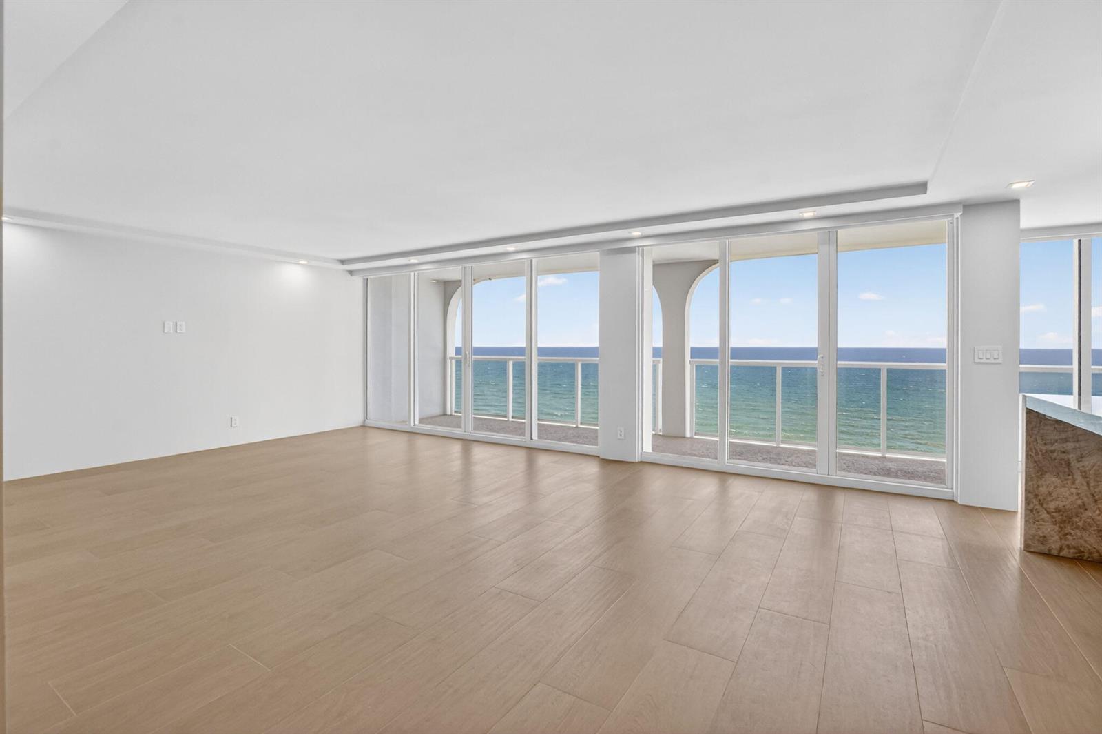 An empty room with light wood-look tile flooring and floor-to-ceiling windows overlooking the ocean — 2800 S Ocean Boulevard # 23c, Boca Raton FL 33432, BOCA RATON, FL
