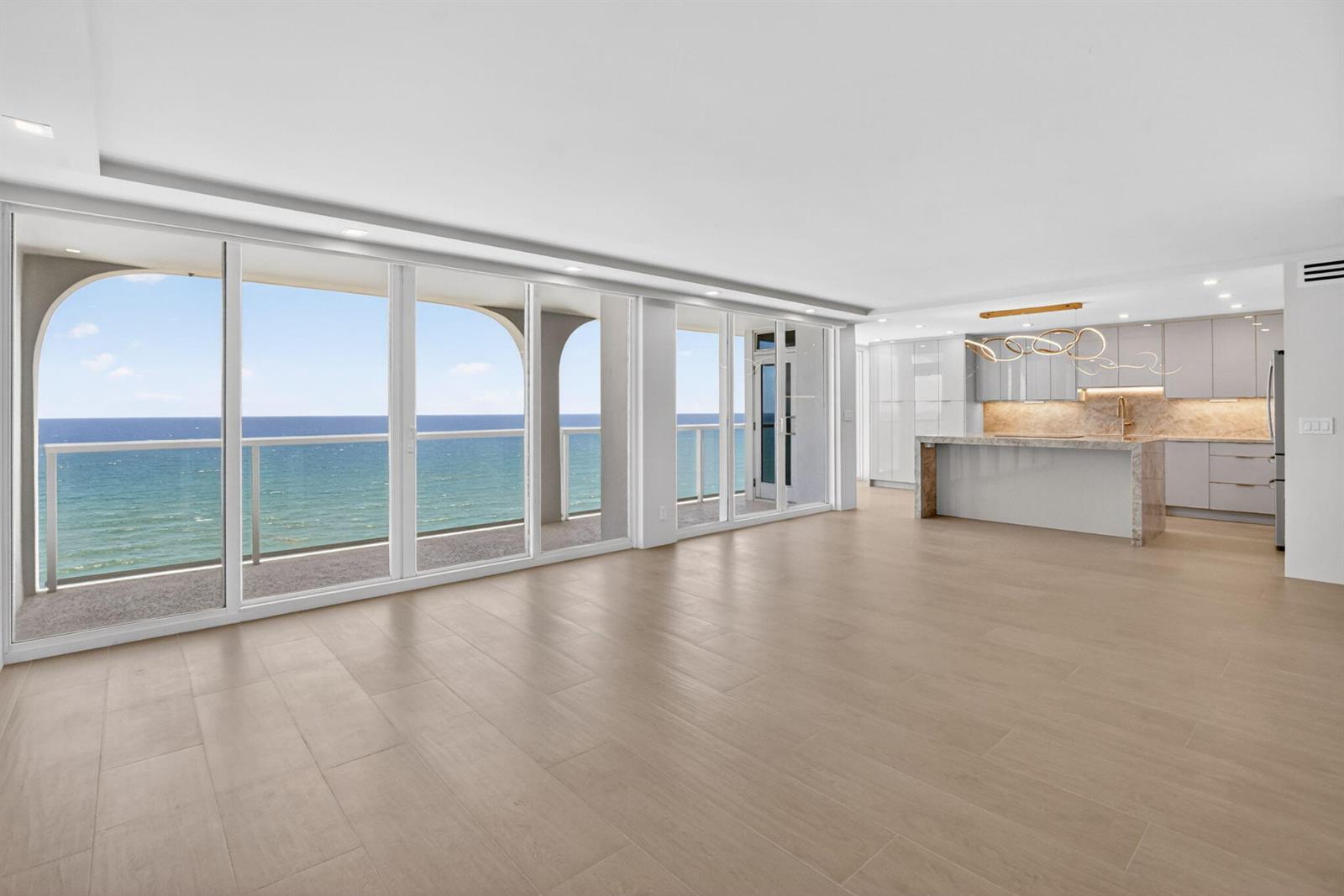 An open-concept living area features light wood-look tile floors, a modern kitchen, and ocean views — 2800 S Ocean Boulevard # 23c, Boca Raton FL 33432, BOCA RATON, FL