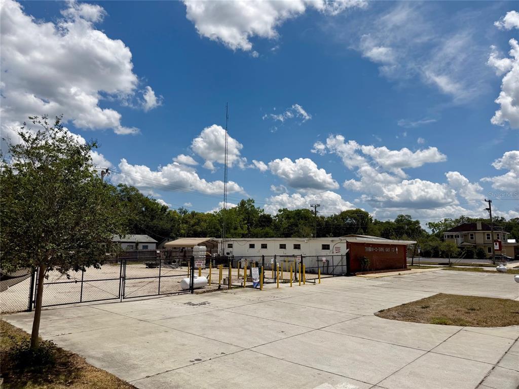 A fenced commercial lot features a white building labeled Therm-O-Tang Gas Co. under a blue sky — 414 W 9TH STREET, SANFORD, FL