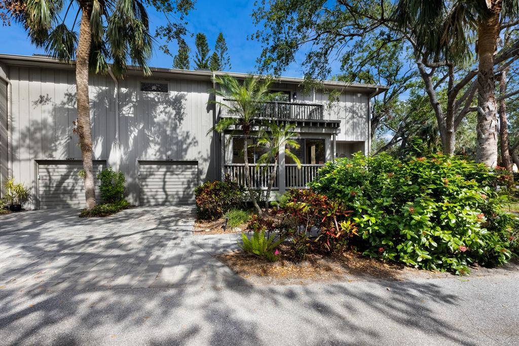 A two-story gray townhouse with a paved driveway, garage doors, and a second-floor balcony — 1479 LANDINGS CIRCLE UNIT 41, SARASOTA, FL