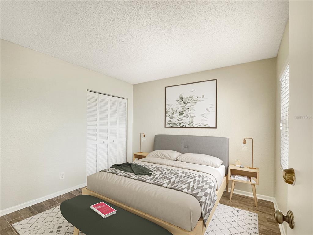 A bedroom features a gray upholstered bed, two wooden nightstands, and a white closet — 484 SANTA CRUZ PLACE NE UNIT D, ST PETERSBURG, FL