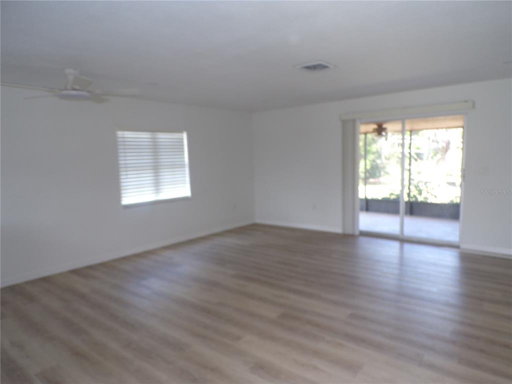 A white closet door stands in the foreground, opening to a room with wood-look flooring — 421 ORCHID DRIVE, PUNTA GORDA, FL