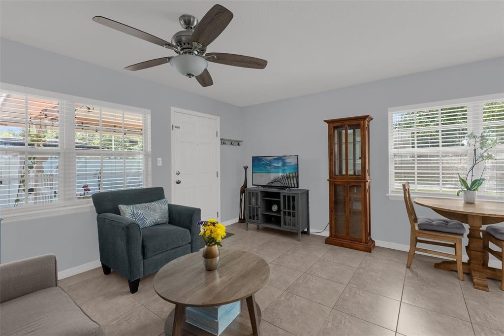 A living room features tile flooring, a ceiling fan, a blue armchair, and a dining area — 3626 GRANT BOULEVARD, ORLANDO, FL