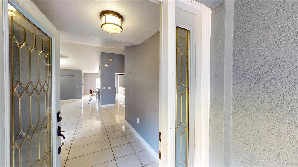A view from an open front door into a tiled entryway with gray walls — 22262 SEYBURN TERRACE, PORT CHARLOTTE, FL