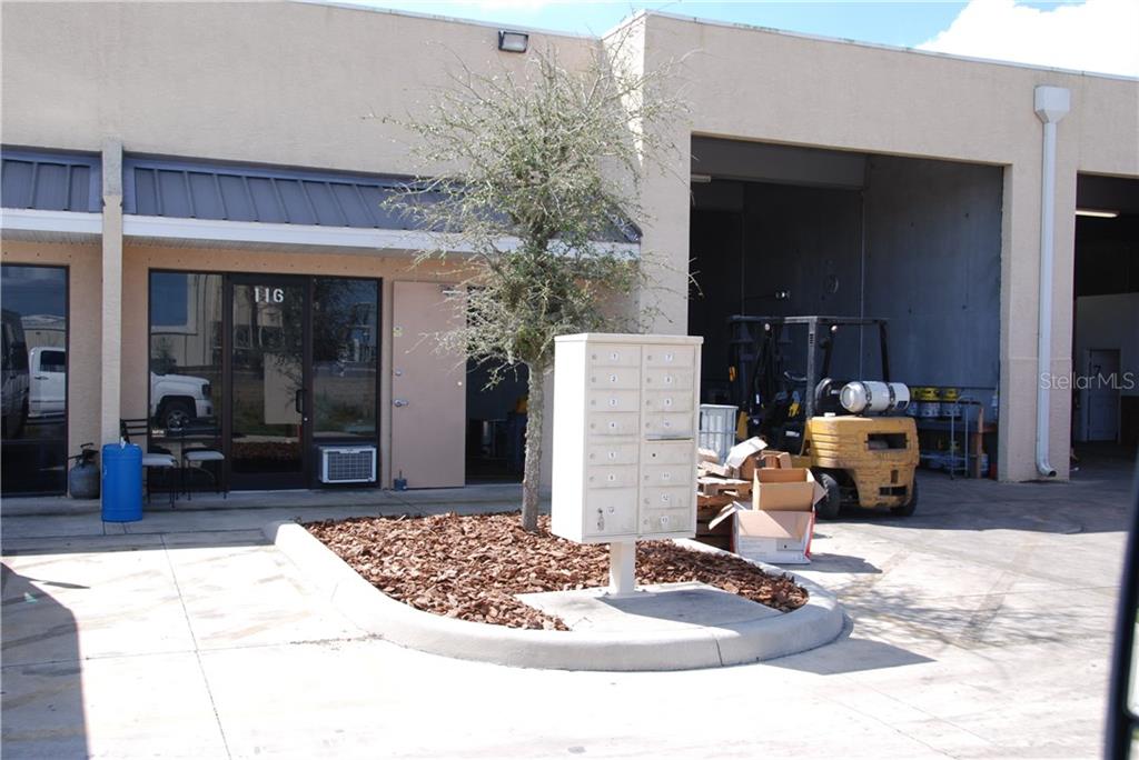An exterior view shows a commercial building entrance with a central mailbox unit and forklift — 28041 AIRPARK DRIVE UNIT 123,121,115,110,101, PUNTA GORDA, FL