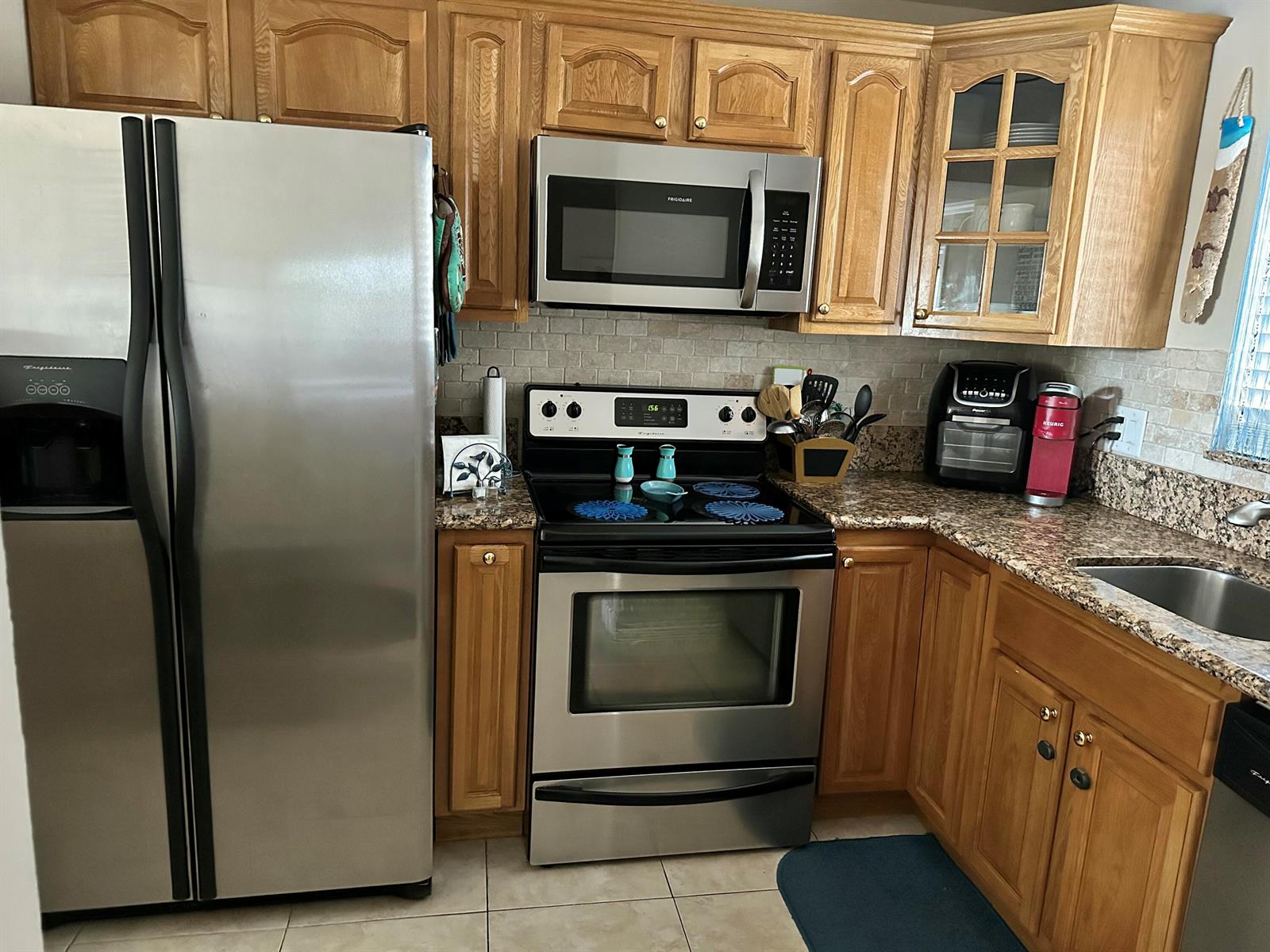 A kitchen with oak cabinets, stainless steel appliances, and granite countertops — 912 Pine Drive # 211, Pompano Beach FL 33060, POMPANO BEACH, FL