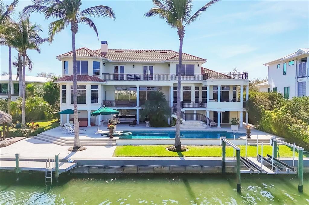 A large waterfront house with a swimming pool, palm trees, and a private boat dock — 1137 N LAKE SHORE DRIVE, SARASOTA, FL