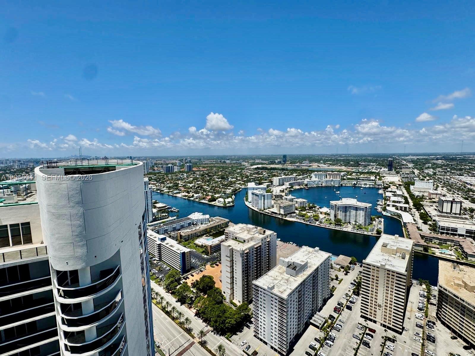 An elevated exterior view shows a tall residential building overlooking a canal and city skyline — 1830 S Ocean Dr # 4806, Hallandale Beach FL 33009, HALLANDALE BEACH, FL