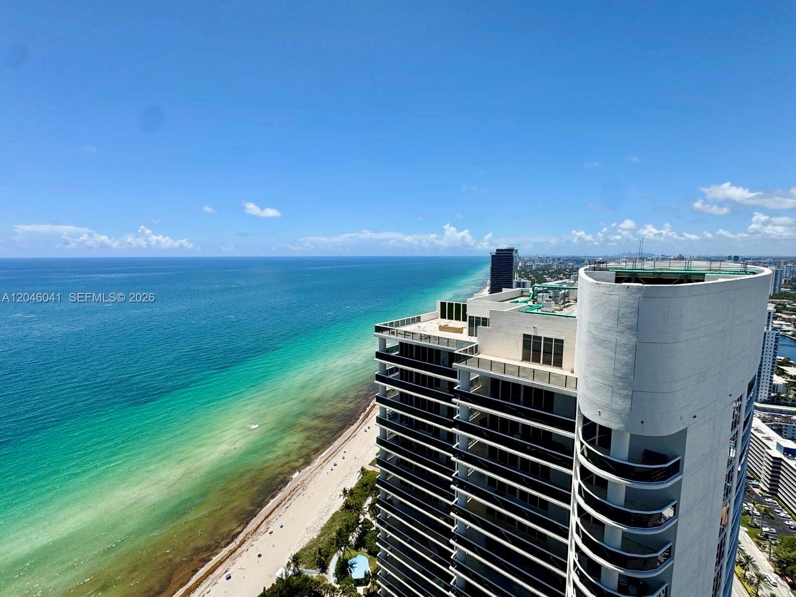 An aerial view shows a high-rise building overlooking a beach and the ocean — 1830 S Ocean Dr # 4806, Hallandale Beach FL 33009, HALLANDALE BEACH, FL