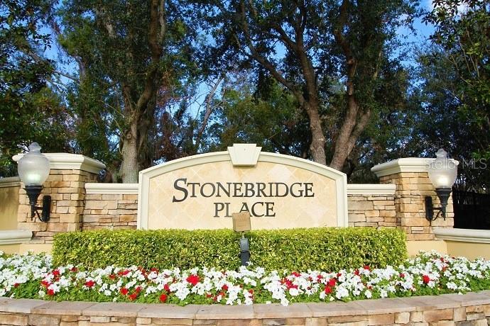 A stone entrance sign for Stonebridge Place features landscaping and two decorative outdoor lamps — 6434 CAVA ALTA DRIVE UNIT 304, ORLANDO, FL