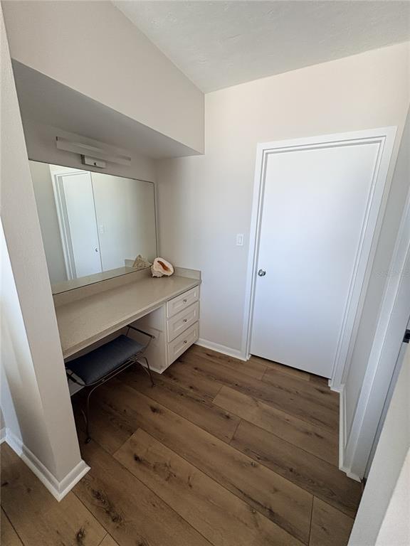 A vanity area with a mirror, drawers, and a stool sits beside a closed door — 601 N ATLANTIC AVENUE UNIT 4080, NEW SMYRNA BEACH, FL