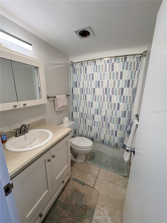 A bathroom features a vanity with a white cabinet, a toilet, and a shower curtain — 601 N ATLANTIC AVENUE UNIT 4080, NEW SMYRNA BEACH, FL