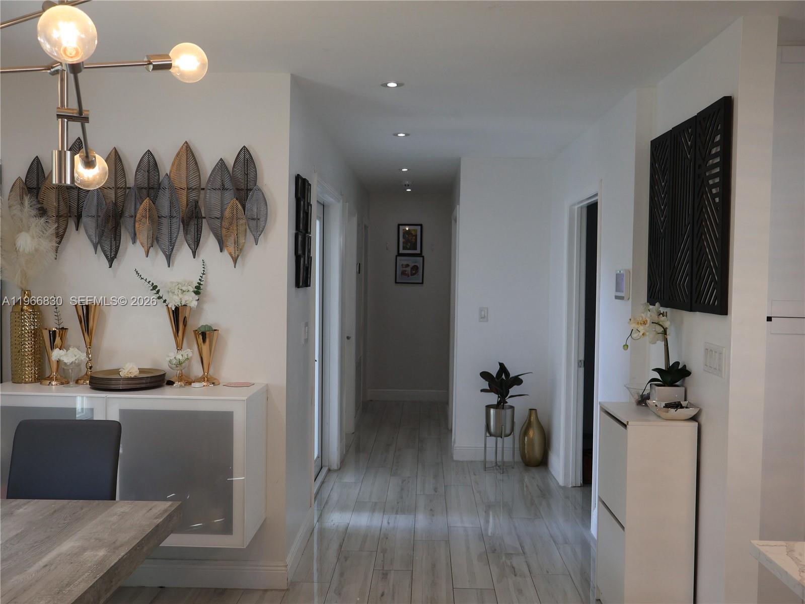 A bright hallway connects a dining area with modern decor to other rooms in the home — 5505 SW 9th St # 0, Margate FL 33068, MARGATE, FL