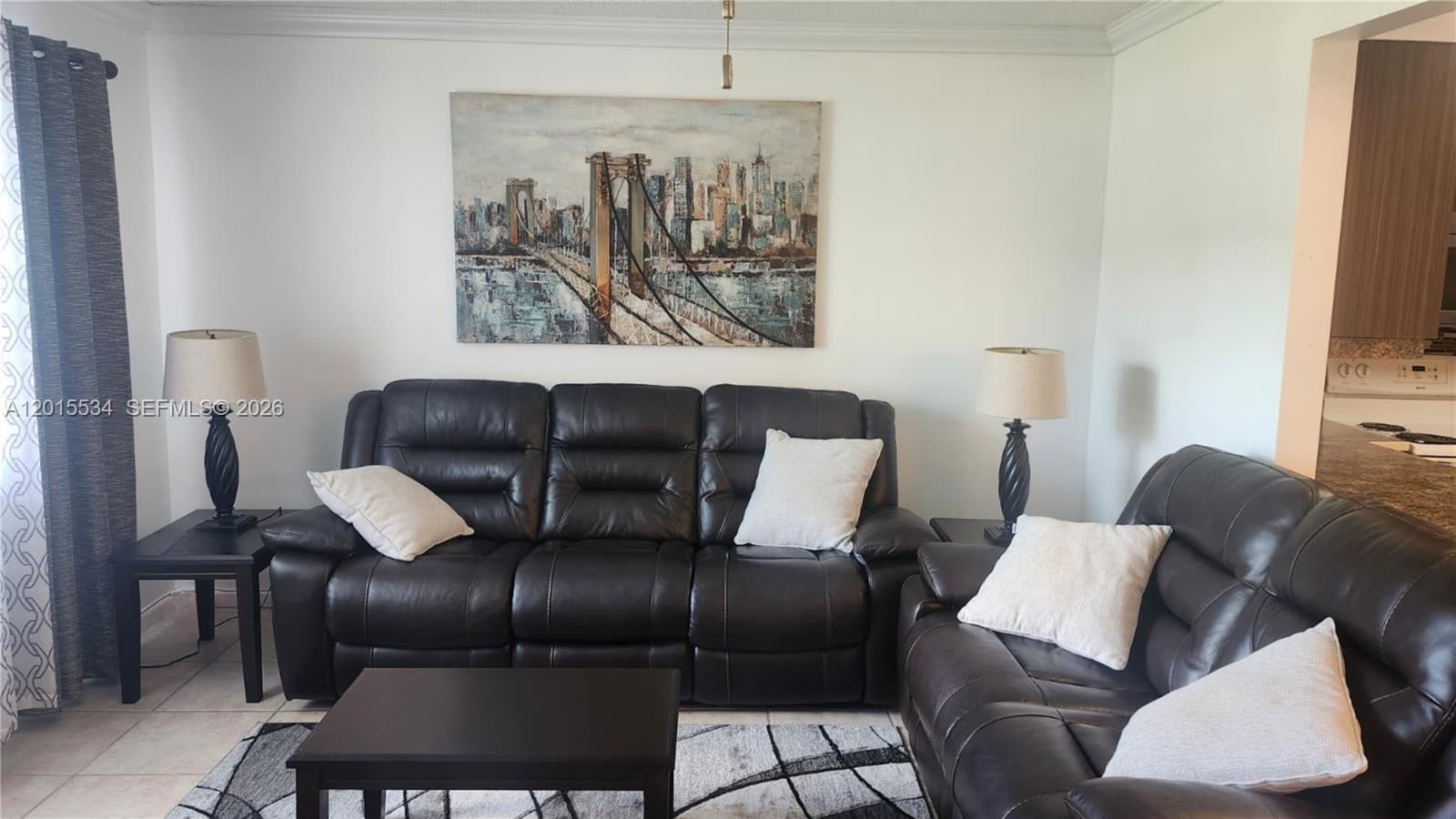 A living room features dark leather sofas, a city skyline painting, and a coffee table — 226 Markham K # 226, Deerfield Beach FL 33442, DEERFIELD BEACH, FL