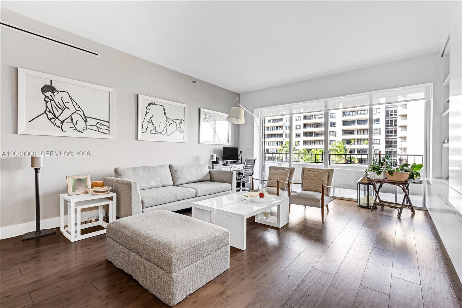 A living room features a grey sofa, white coffee table, and balcony access with city views — 201 Crandon Blvd # 530, Key Biscayne FL 33149, KEY BISCAYNE, FL
