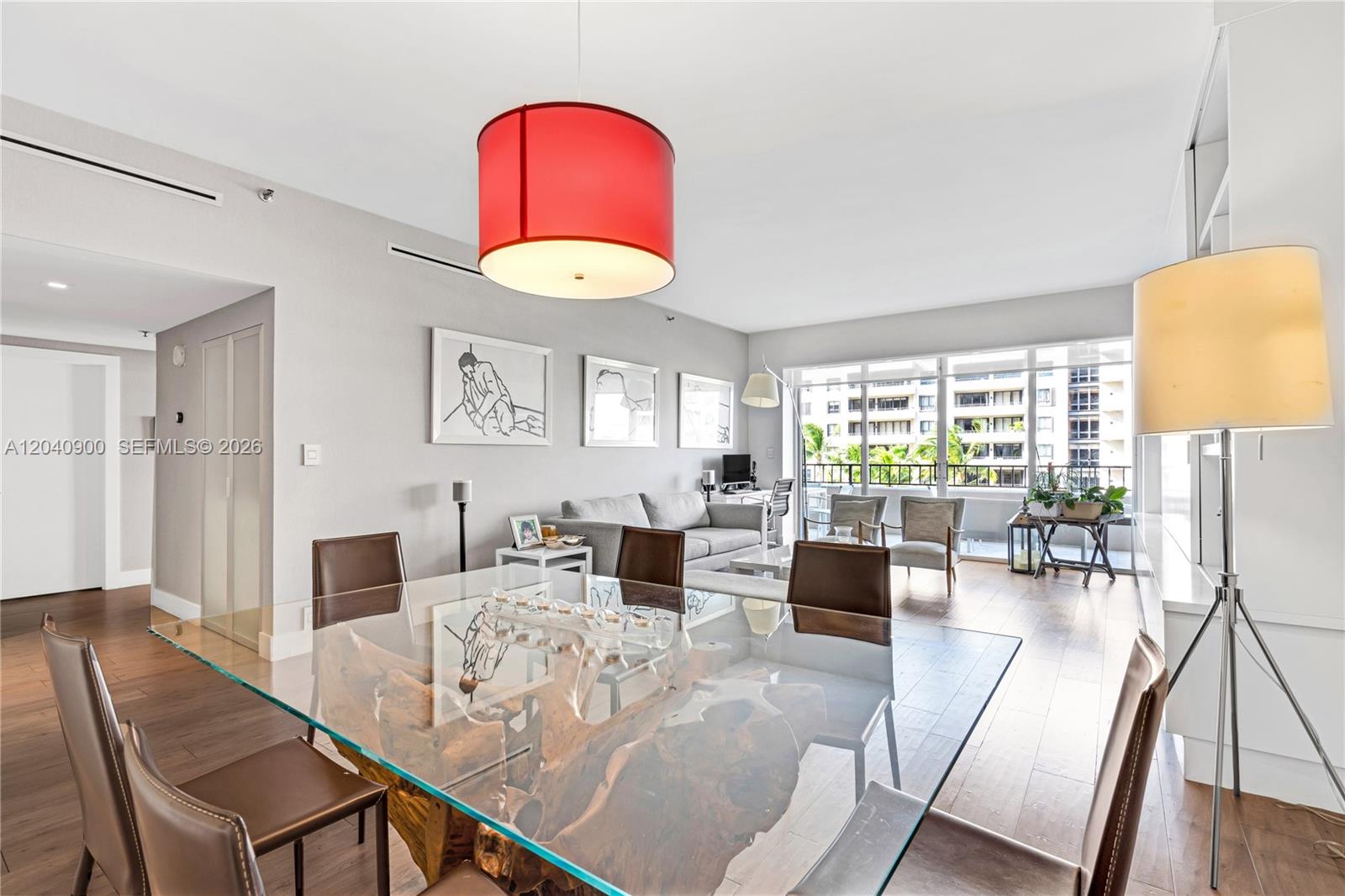 A dining area with a glass-topped wood table leads into a living room with balcony access — 201 Crandon Blvd # 530, Key Biscayne FL 33149, KEY BISCAYNE, FL