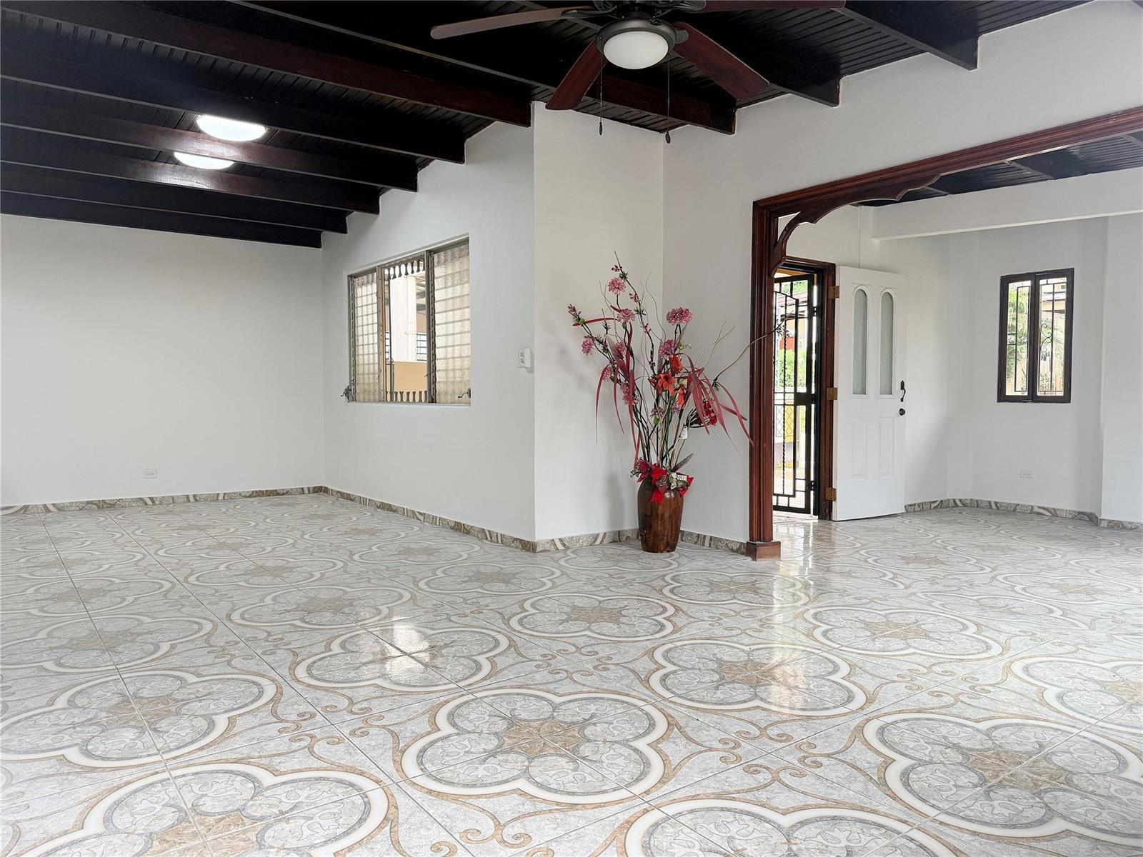 An empty room features patterned tile flooring, white walls, and a dark wood beamed ceiling — Panama City, Panama N Panama City, PA, PA