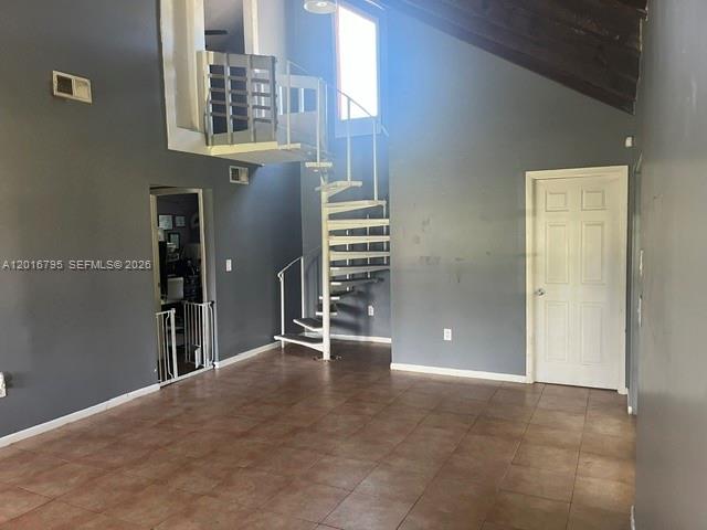A room with tile flooring, gray walls, a spiral staircase, and a white door — 5900 Bamboo Dr, Fort Pierce FL 34982, FORT PIERCE, FL