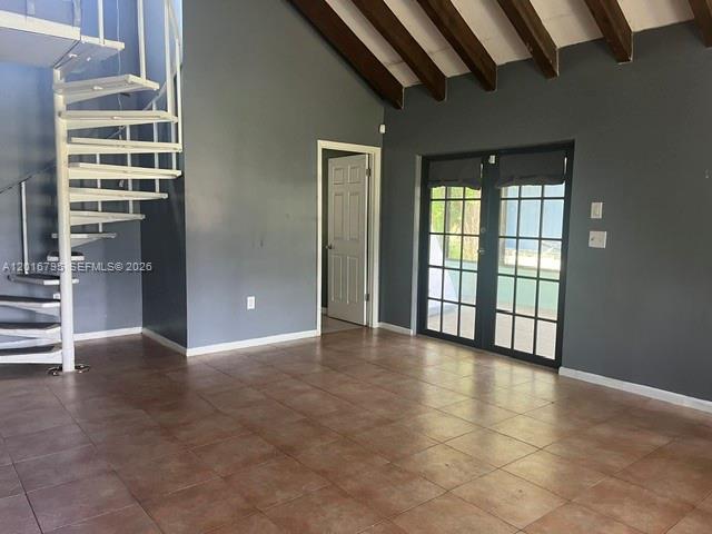 A room with tile floors, a spiral staircase, and French doors under a vaulted ceiling — 5900 Bamboo Dr, Fort Pierce FL 34982, FORT PIERCE, FL