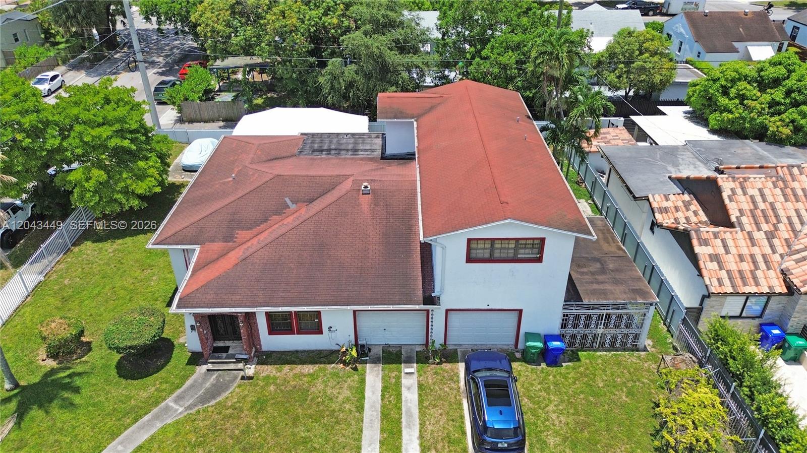 An aerial view shows a two-story house with a red roof and a two-car garage — 1000 NW 47th St, Miami FL 33127, MIAMI, FL