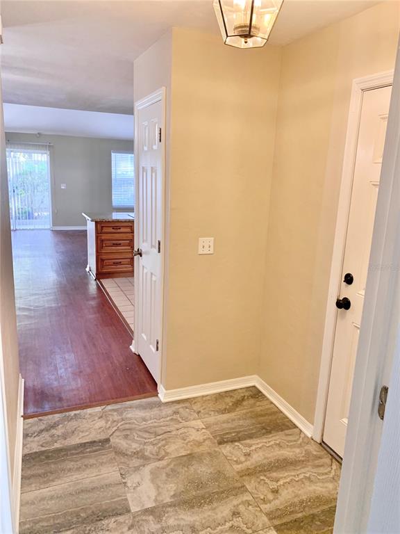 A tiled entryway leads to a living area with wood-look flooring and a kitchen island — 5268 SW 97TH WAY, GAINESVILLE, FL