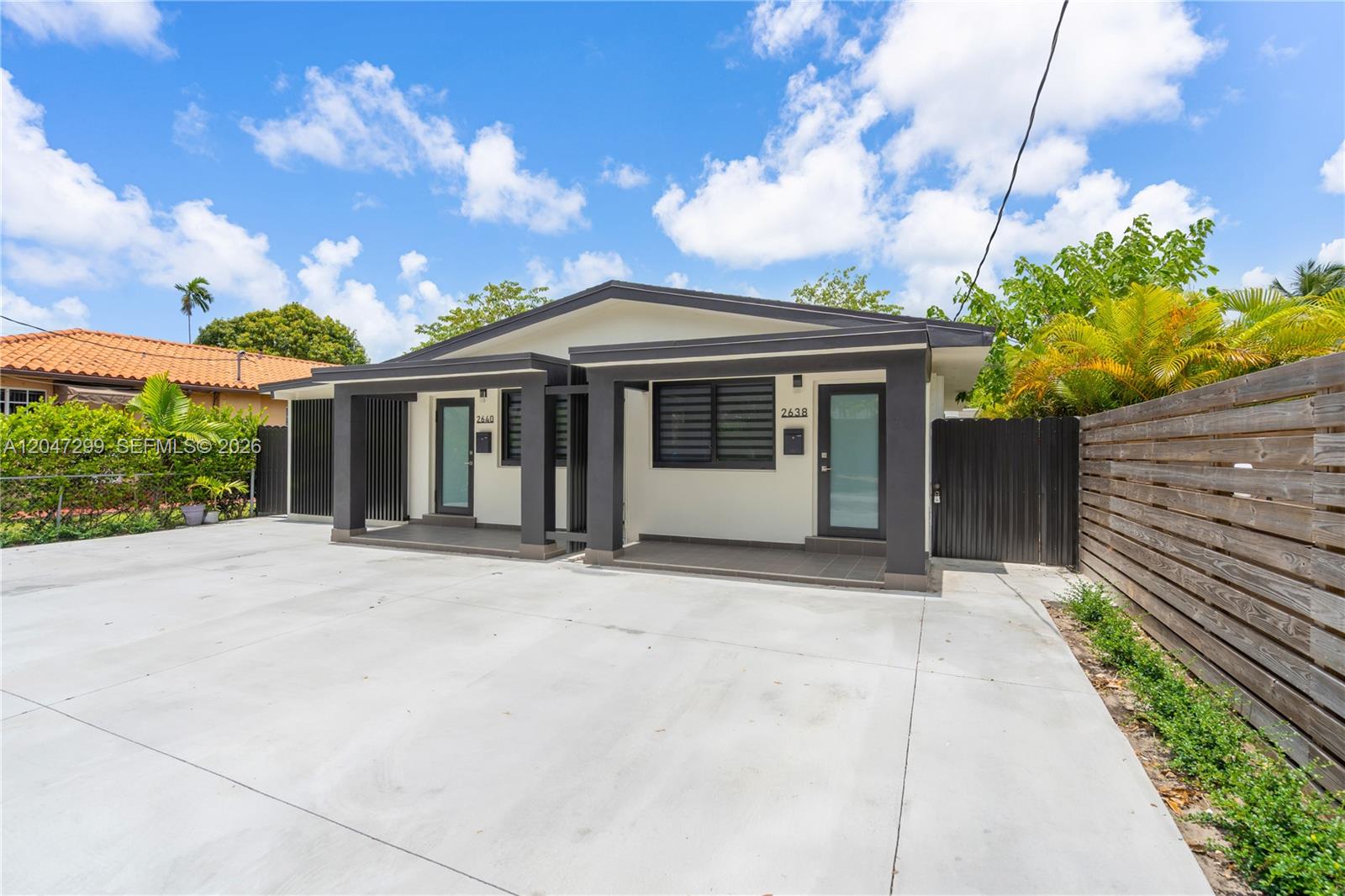A modern duplex with a concrete driveway, dark trim, and two separate front entrances — 2638 SW 30th Ct # 2638, Miami FL 33133, MIAMI, FL