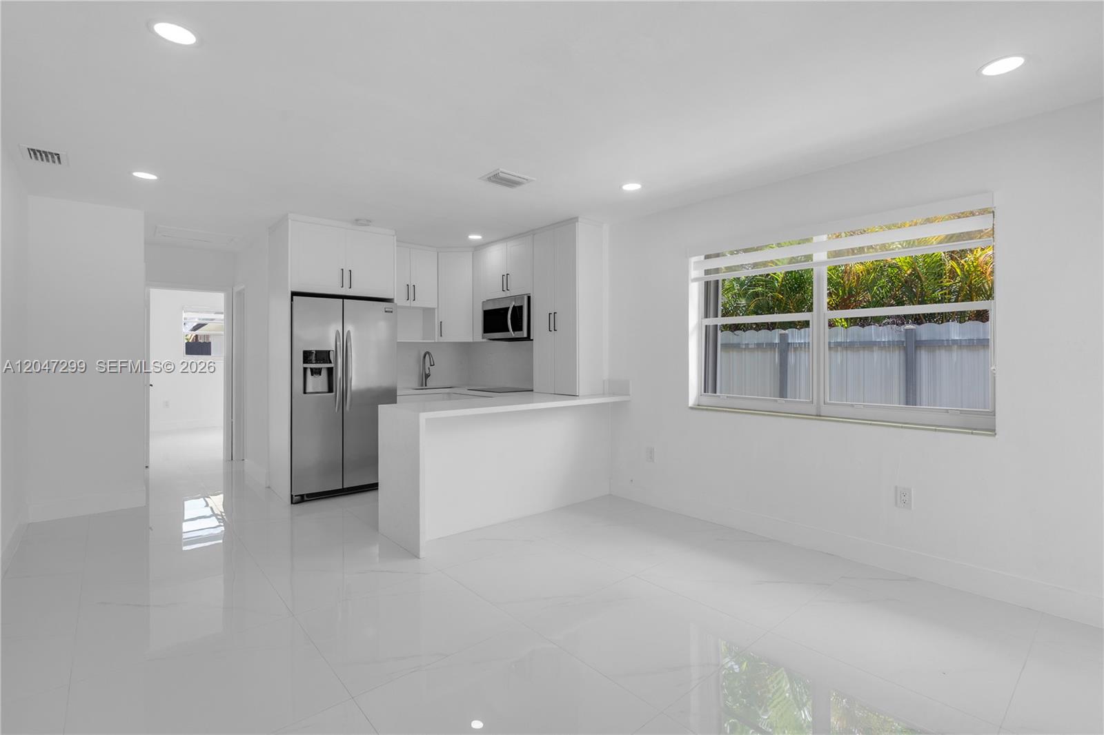 A modern kitchen with white cabinets, stainless steel appliances, and a breakfast bar — 2638 SW 30th Ct # 2638, Miami FL 33133, MIAMI, FL