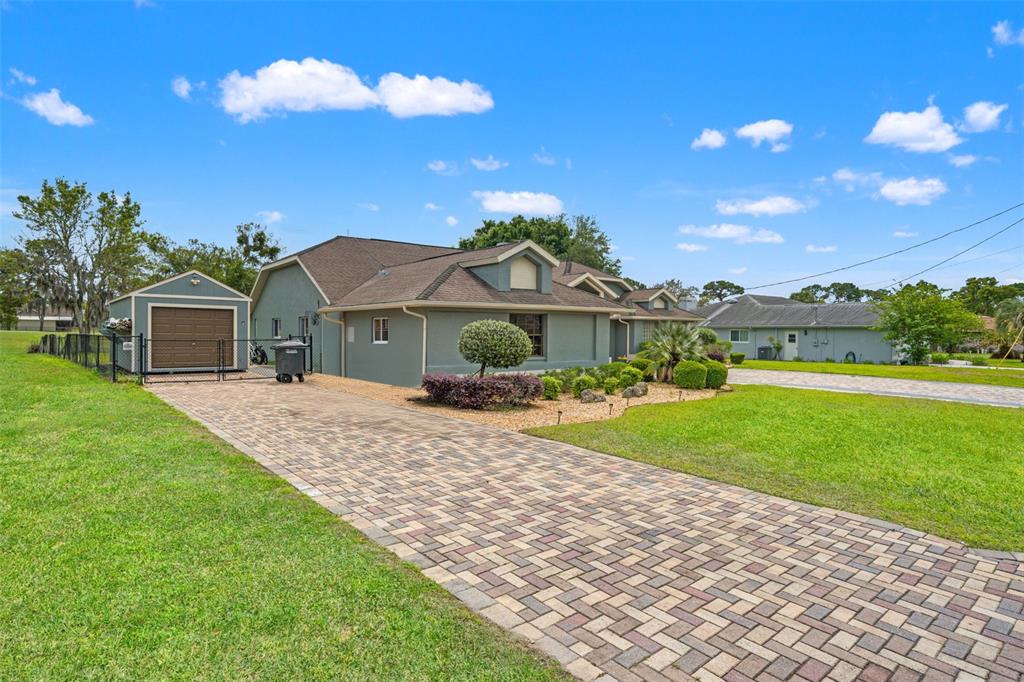 A single-story house with a paved driveway, a detached garage, and a landscaped front yard — 5052 FLORENTINE COURT, SPRING HILL, FL