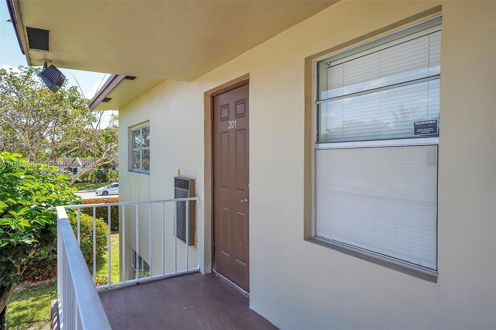 An exterior balcony leads to a brown door labeled 201 next to a window — 7200 NW 4th Pl # 201, Margate FL 33063, MARGATE, FL