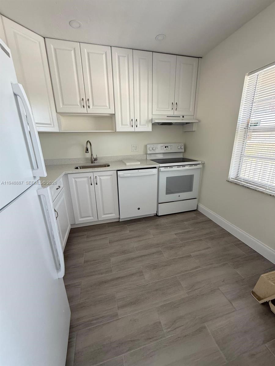A kitchen features white cabinets, stainless steel appliances, and light-colored wood-look tile flooring — 7200 NW 4th Pl # 201, Margate FL 33063, MARGATE, FL