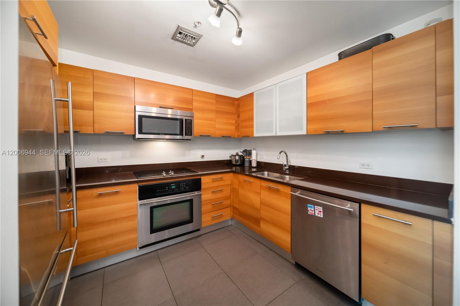 A kitchen features light wood cabinets, stainless steel appliances, and dark countertops — 3301 NE 1st Ave # M0308, Miami FL 33137, MIAMI, FL