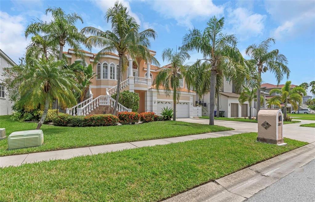A two-story house with a grand staircase, palm trees, and a driveway in a suburban neighborhood — 3187 SHORELINE DRIVE, CLEARWATER, FL