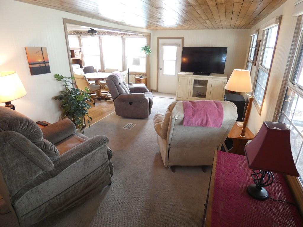 A living room features carpeted floors, a wood-paneled ceiling, and several recliner chairs — 12674 SEMINOLE BOULEVARD UNIT S8, LARGO, FL
