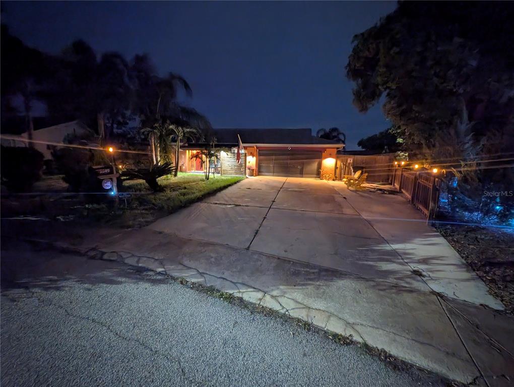 A single-story house with a concrete driveway and palm trees at night — 3849 EDGEMONT DRIVE, NEW PORT RICHEY, FL