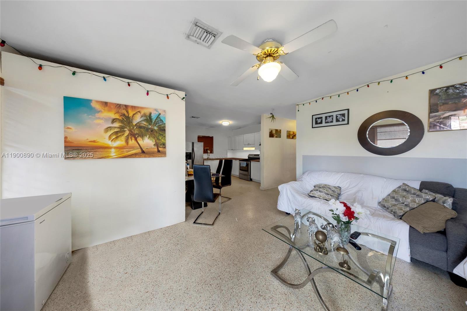 A living room with a white sofa, glass coffee table, and an open kitchen area — 1515 NW 33rd Ave, Miami FL 33125, MIAMI, FL