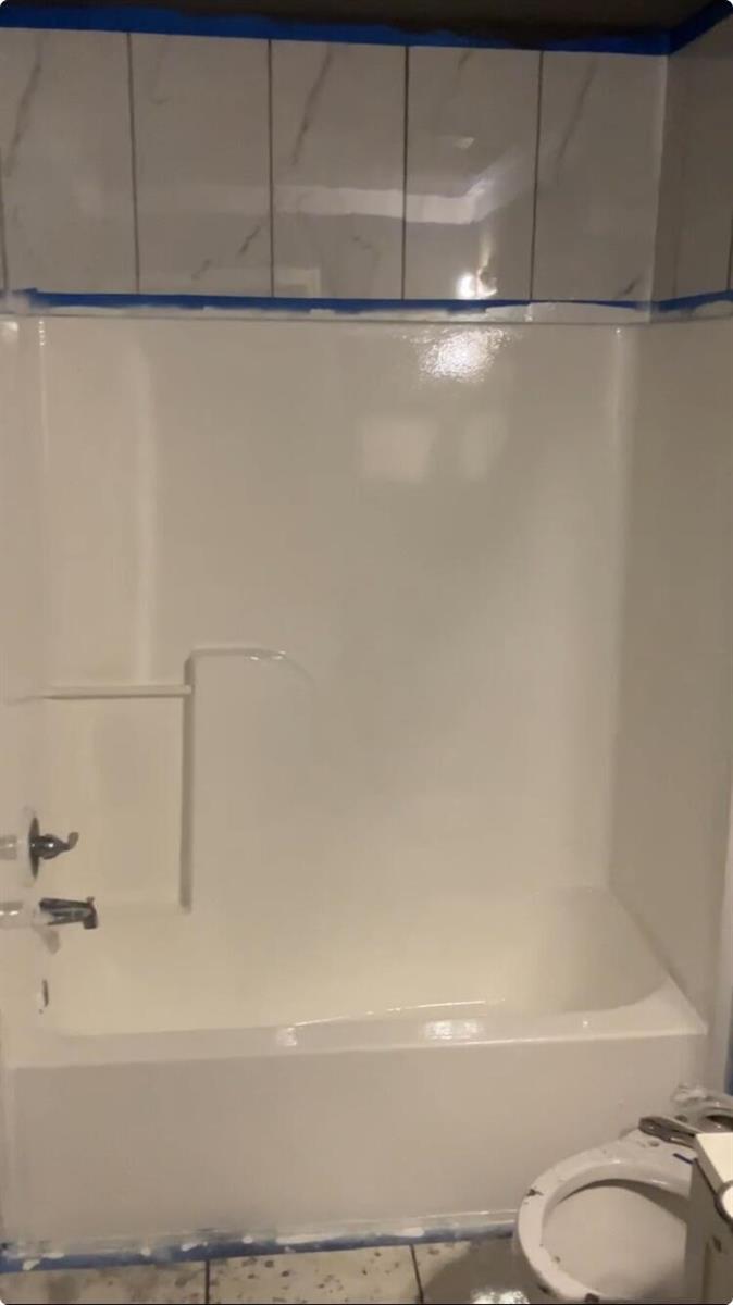 A white bathtub and shower surround with a tiled wall above it — 2837 Stoneway Lane # D, Fort Pierce FL 34982, FORT PIERCE, FL