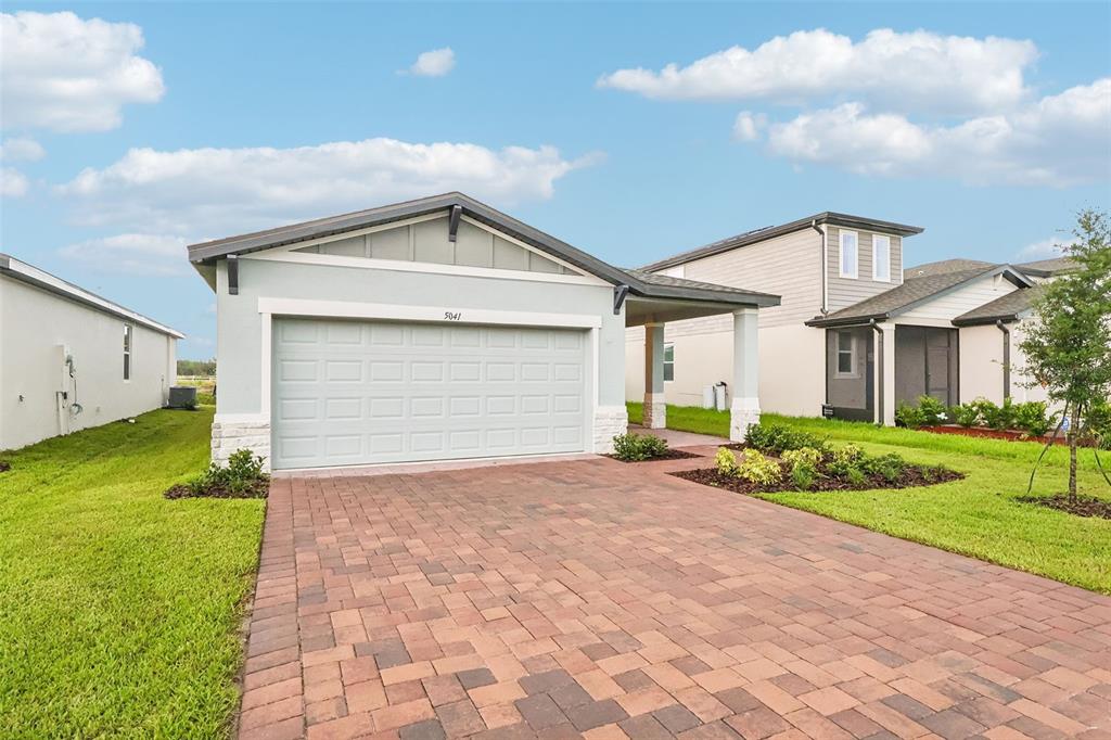 A single-story house with a light blue exterior, a two-car garage, and a paved driveway — 5041 KAIA AVENUE, WINTER HAVEN, FL