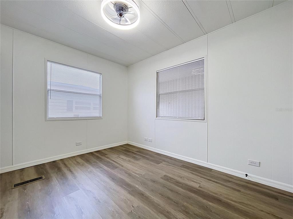 A kitchen features white cabinets, stainless steel appliances, and a stone countertop — 6965 FORT KING ROAD, ZEPHYRHILLS, FL