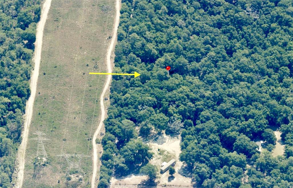 An aerial view shows a wooded lot adjacent to a power line easement and dirt road — Track 28 SW 150TH STREET, DUNNELLON, FL