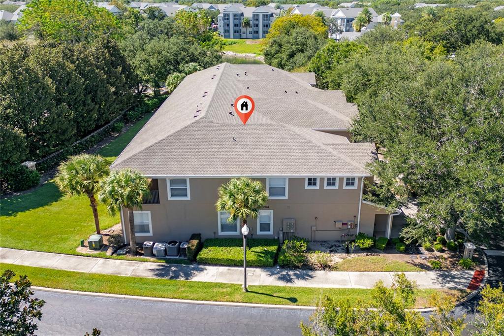 An aerial view of a multi-story residential building with a shingled roof and landscaping — 6422 AGASTIA COURT UNIT 101, ORLANDO, FL