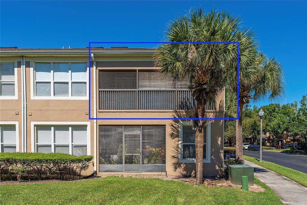 A two-story building exterior featuring a screened-in upper balcony and a ground-floor screened patio — 6422 AGASTIA COURT UNIT 101, ORLANDO, FL