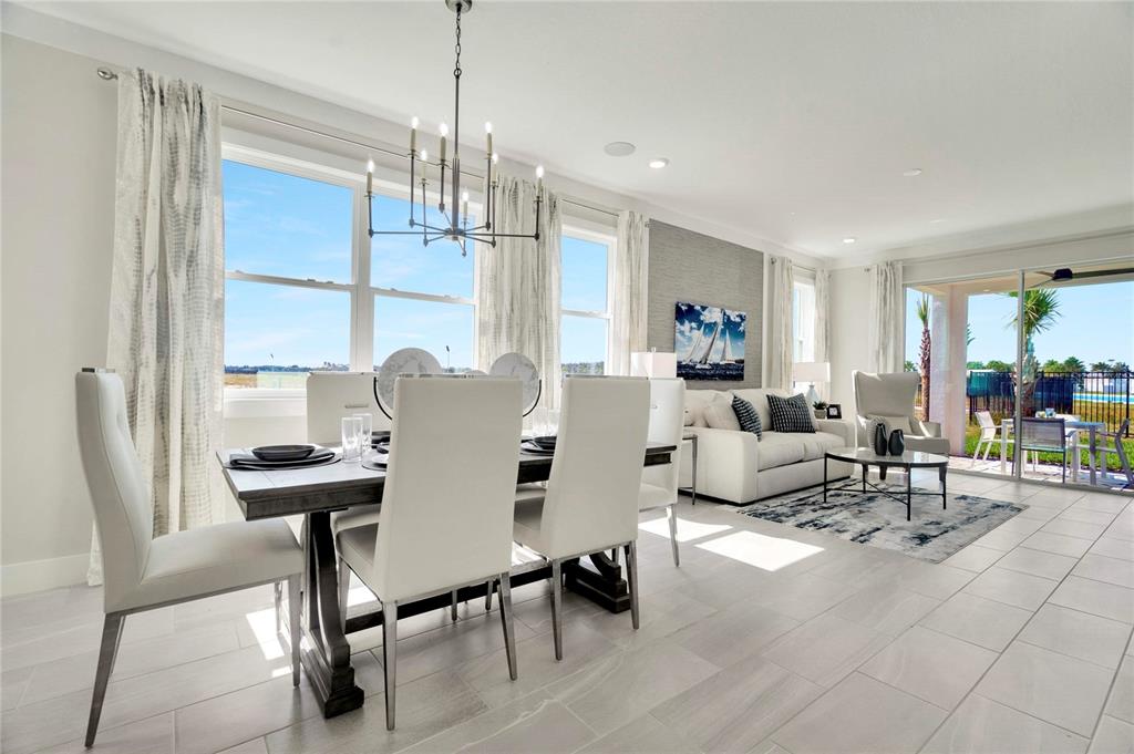 A modern kitchen features white cabinetry, a central island, stainless steel appliances, and wood flooring — 31856 CLOVER FIN COURT, WESLEY CHAPEL, FL