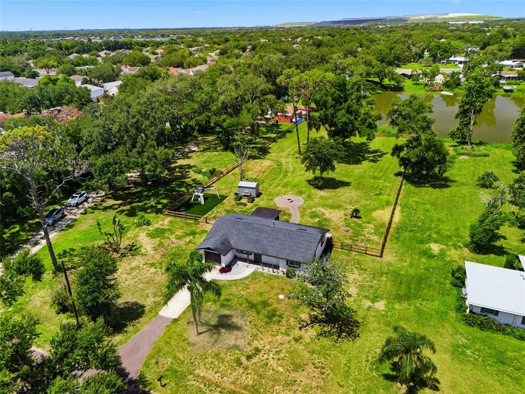 An aerial view shows a single-story house with a dark roof on a large grassy lot — 6509 REED DRIVE, RIVERVIEW, FL