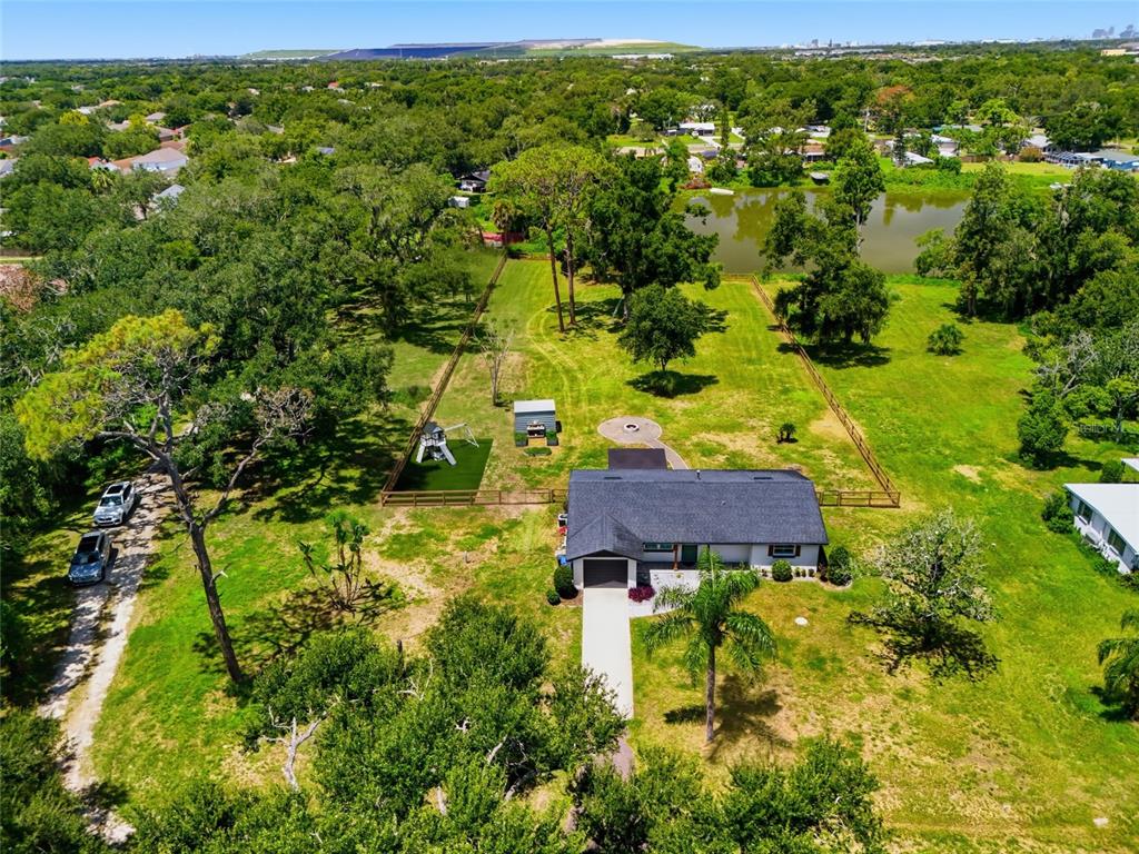An aerial view shows a single-story house with a fenced backyard and a small pond — 6509 REED DRIVE, RIVERVIEW, FL