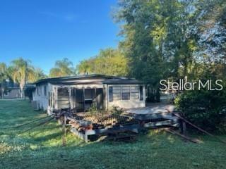 A single-story house with a screened porch and a wooden deck in a grassy yard — 1501 PEARL STREET, LONGWOOD, FL